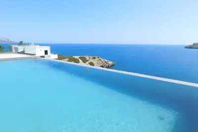 Image de Maison Hermès, Plaka. Villa de luxe au sommet d'une falaise avec grande piscine à débordement et vue sur la mer.