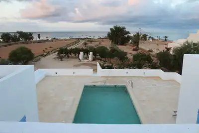 Image de villa avec piscine en bord de mer et plage dans un sité féerique