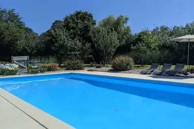 Image de Conversion de grange moderne avec piscine extérieure chauffée partagée et tennis de pelouse