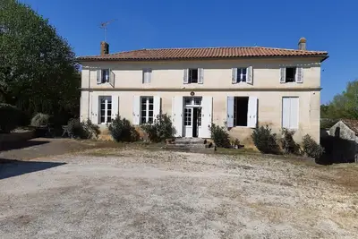 Image de Grande maison en pierre de taille entourée de grands espaces verts