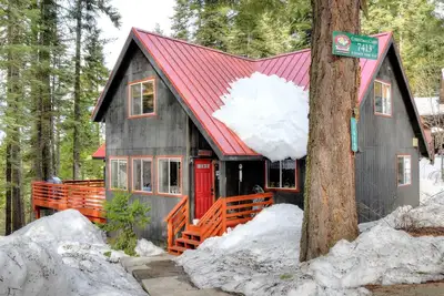 Image de Christmas Cabin est une charmante maison sur le thème de Noël nichée au milieu des pins à sucre avec une v. . .