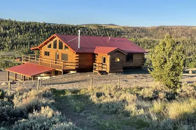 Image de Eagle Nest, maison en bois rond avec vue panoramique sur les montagnes et la rivière.