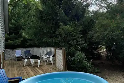 Image de Piscine, bain à remous, cadre boisé, beaux jardins, véranda