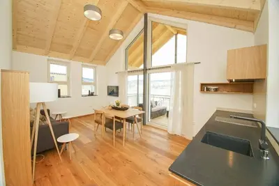 Image de Chalet de vacances avec véranda couverte avec mobilier de salon et chaise longue flottante.