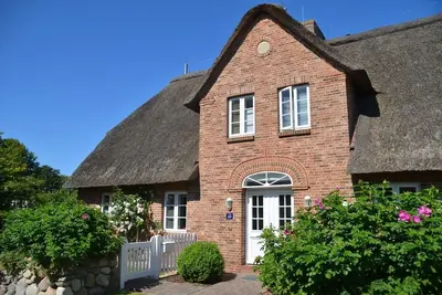 Image de Maison au toit de chaume 4 étoiles avec un grand jardin au centre du village de Süderende