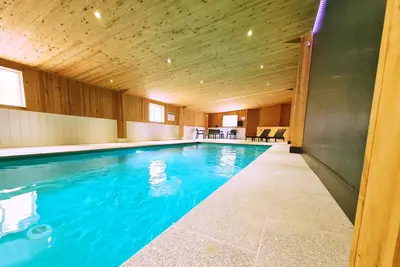 Gîte rural avec piscine intérieure chauffée et vue panoramique.