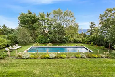 Image de Vues sur l'eau de cette maison immaculée et ensoleillée à Bellport Village avec piscine.