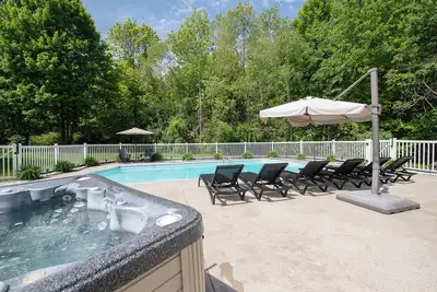 Image de Piscine, bain à remous, tennis de table et véranda avec cheminée donnant sur un ravin boisé