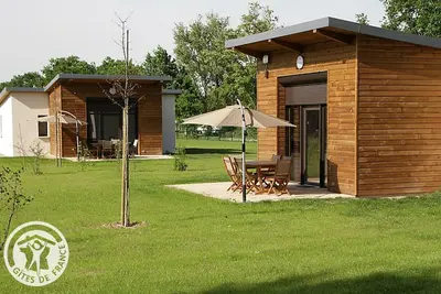 Image de Chalets confortables au bord d'un étang avec terrasse, jardin et nombreuses activités.
