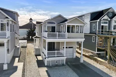 Image de Offre un salon ouvert, une salle à manger et un coin cuisine avec des plafonds cathédrale.