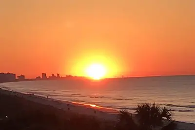 Image de Lever de soleil Ă couper le souffle et vue du coucher du soleil d'un 28 'Getaway Oceanfront Balcon