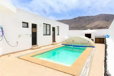 Image de Famara Beach House sur la côte avec piscine partagée, vue sur l'océan et la montagne et Wi-Fi