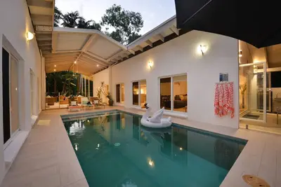Image de Pavillons dans les palmiers Piscine chauffée Court chemin de la plage Cinq chambres 12 personnes