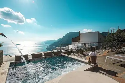 Image de Villa Tecla B: Une villa de deux étages caractéristique face au soleil et à la mer.
