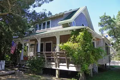 Image de Profitez de ce chalet romantique jardin avec porches couverts, terrasse et véranda spacieuse.
