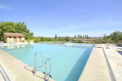 Image de Villa Fontanile E: Un appartement élégant et accueillant qui fait partie d'une villa entourée de verdure.