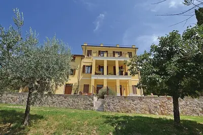 Image de Villa Ovidia: Une ancienne ferme sur trois étages entourée de verdure.