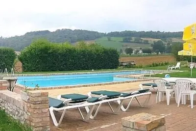 Image de Villa Pavone A: Un appartement confortable qui fait partie d'une villa de deux étages entourée de verdure.