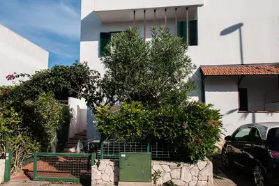 Image de maison mitoyenne dans un village de vacances près de Gallipoli, entourée de verdure.