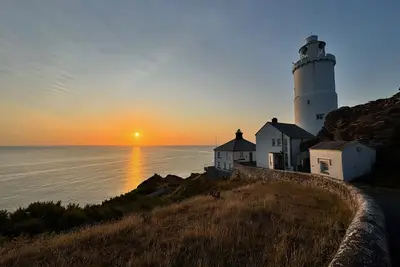Image de Landward Cottage au phare de Start Point avec un panorama à couper le souffle sur la mer.