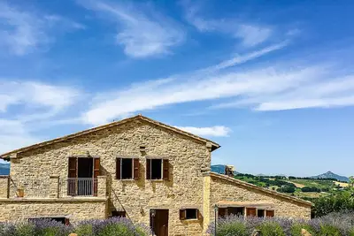 Image de Maison de campagne accueillante avec piscine à débordement et entourée de tournesols. . .