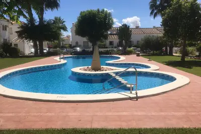 Image de Bungalow près de la plage, bars / restaurants. -Piscine et jardin communautaires. WiFi, AirCon; la télé