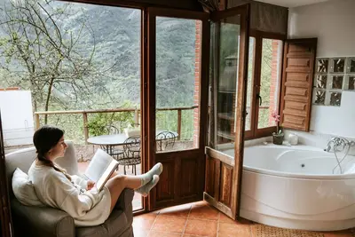 Image de Jacuzzi dans la chambre avec vue sur la montagne, barbecue et cheminée
