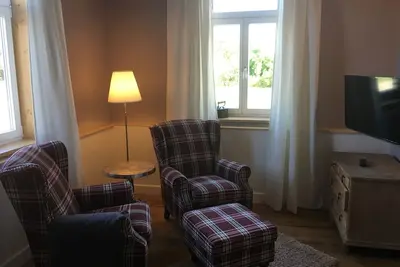 Image de Vivant dans le bâtiment du moulin, entouré de vertes prairies.
