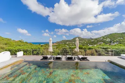Piscine à débordement avec bordure en pierre, belvédère sur la terrasse conçue pour les repas Alfresco