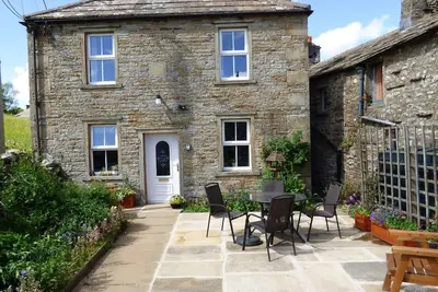 Image de Cottage Dales traditionnel entouré de prés de foin renommés et de murs en pierre sèche
