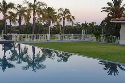 Image de Maison orange avec grand parc et piscine.