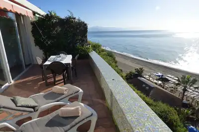 Image de Bungalow en bord de mer précieux avec terrasse ensoleillée et vue imprenable sur la mer.