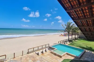 Image de Maison à Cumbuco, les pieds dans le sable, avec deux balcons et une piscine.