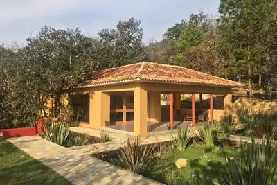 Image de Maison privée dans les bois avec court de tennis.