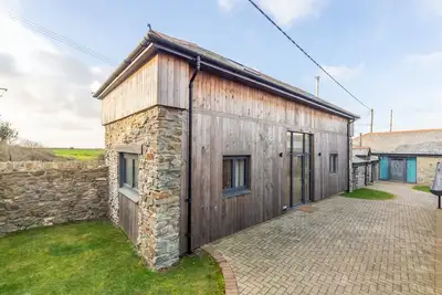 Image de Une grange convertie qui a été restaurée en une maison de vacances lumineuse et moderne.