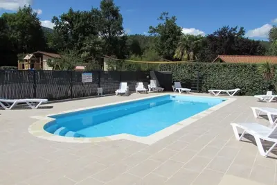Image de chalets en bois dans village de gites avec terrasse, barbecue, piscine et clim