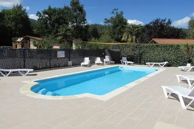 Image de chalets en bois dans villages de gites avec terrasse, barbecue, piscine et clim