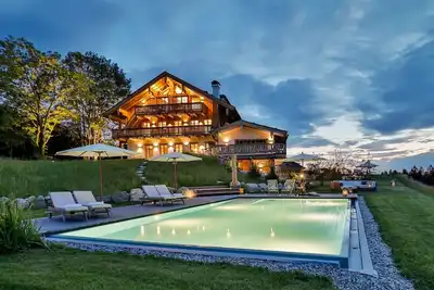Image de Style chalet moderne avec sauna privé, cheminée, hot tub, piscine avec vue sur Chiemsee