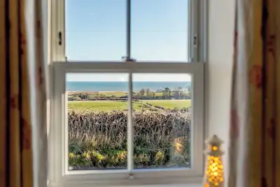 Image de Mid-terraced single storey cottage with lovely views across farmland to the sea on the horizon.