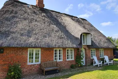 Image de Maison au toit de chaume sur le lac pouvant accueillir jusqu'à 8 personnes avec 4 chambres, cheminée, sauna, billard, ciel