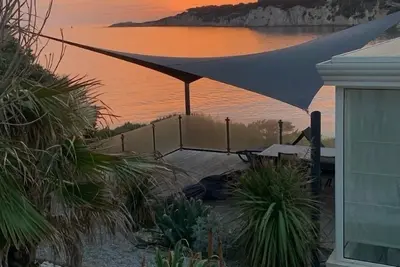 Image de maison pieds dans l'eau accès privé à la mer ainsi qu'une piscine privée