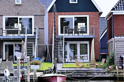Image de Maison moderne avec grande terrasse et jardin sur un canal et une jetée privés