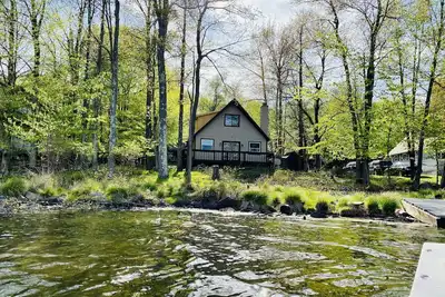Image de Lakefront Reteat with boats and fire pit.
