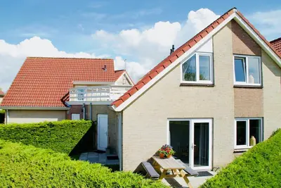 Image de Prêt pour des vacances à la plage? Cette maison de vacances moderne et agréablement meublée est située dans une cour calme et conviviale dans le magnifique parc “Noordzeepark”.