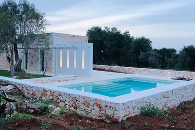 Image de White stone typical apulian villa with barrel roof surrounded by olive trees.
