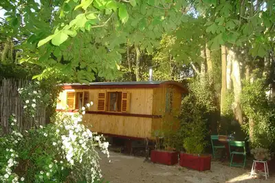 Image de roulotte bulgare en bois dans un jardin arboré