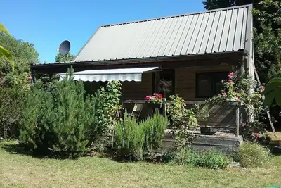 Image de Petite maison en bois indépendante dans parc entretenu et clôturé.
