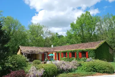 Image de Grande maison en pierre entre forêt et champs avec piscine