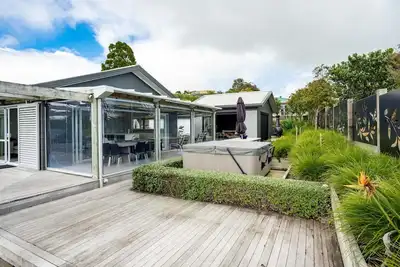 Image de All Decked Out - Modern holiday home with multiple decks including a covered outdoor entertaining space with open fireplace and plastic blinds. Close to shops, cafe, golf course, estuary and Mangawhai Activity Zone. Pet Friendly.