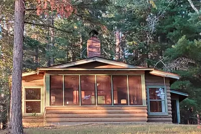 Rustic cabin in remote wooded area on point overlooking lake.